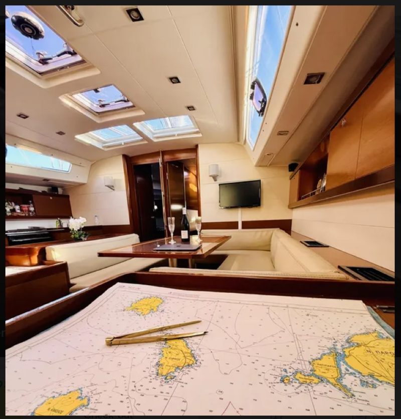 Paper chart of the Greek islands with dividers and parallel rule on a yacht saloon table